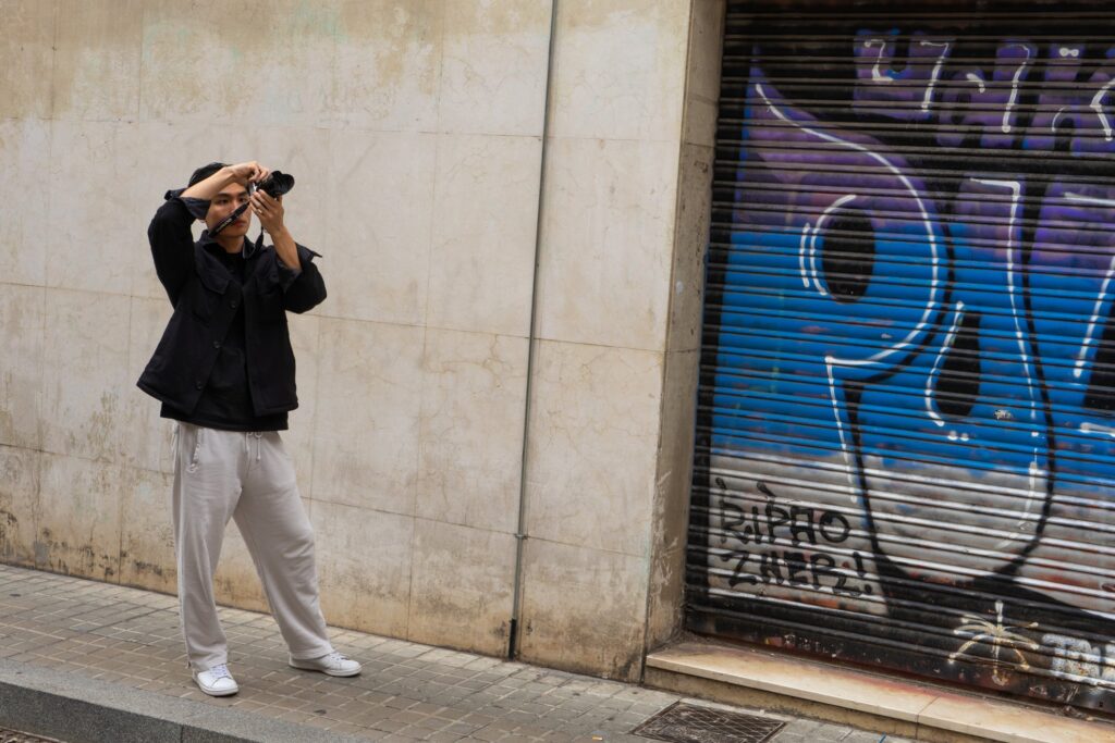 A tourist taking a photo of Antoni Gaudí building.