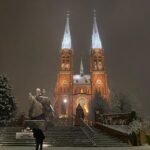 Man sneezes in front of Rybnik Basilica.