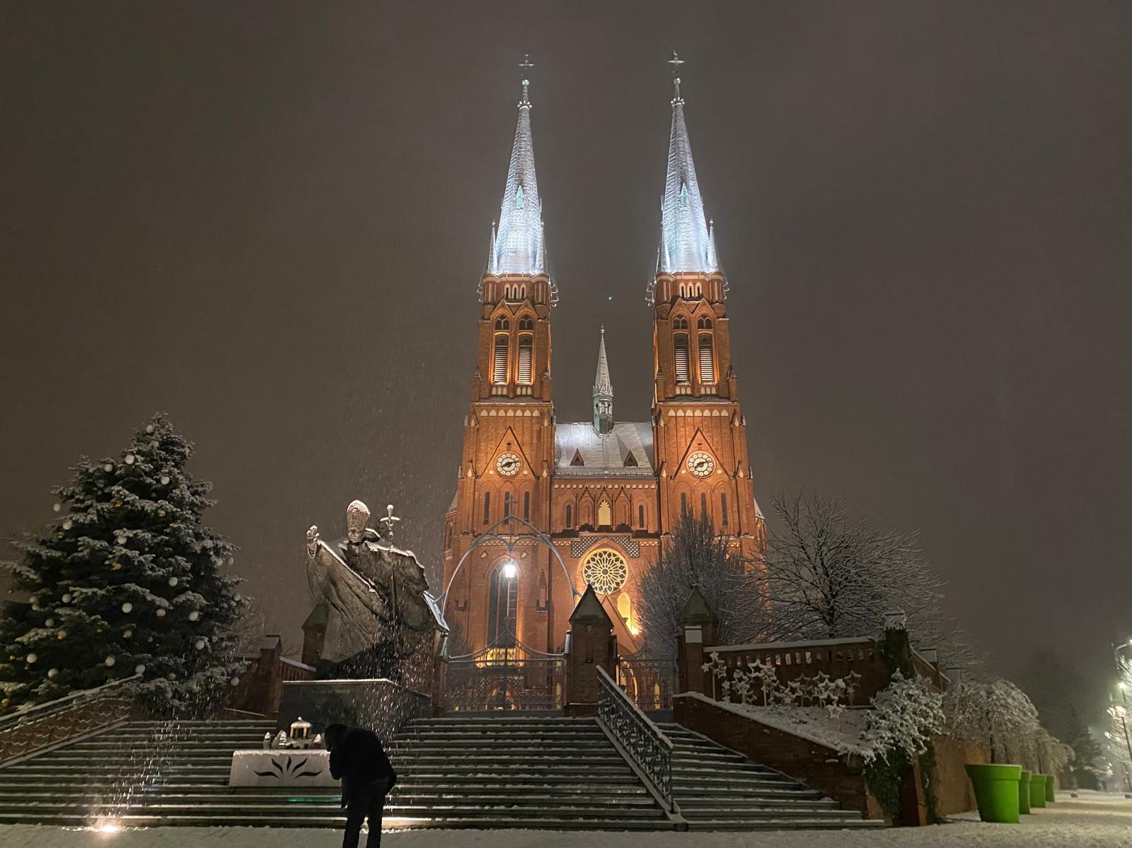 Man sneezes in front of Rybnik Basilica.